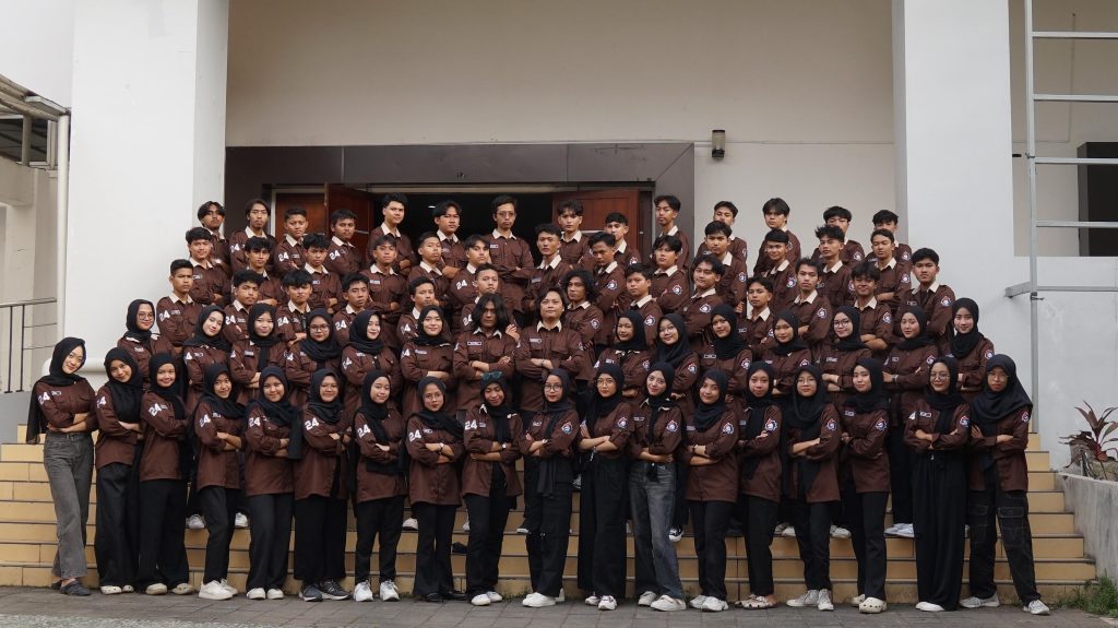 Kolase gambar yang menampilkan kelompok besar mahasiswa/komunitas. Satu kelompok mengenakan kemeja seragam cokelat tua (mirip PDH) dan kelompok lain mengenakan kemeja seragam abu-abu muda (mirip PDL/lapangan). Kemeja ini ideal untuk seragam event atau lapangan, diproduksi oleh konveksi di jogja yang melayani konveksi baju PDL/PDH dan bordir jogja presisi. Cocok untuk kebutuhan konveksi tambang atau organisasi kampus.
